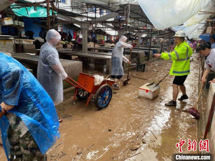 圖為7月26日，暴雨引發(fā)的洪水過境后，重慶萬州區(qū)分水鎮(zhèn)政府干部職工及志愿者清掃淤泥和垃圾。　　重慶萬州區(qū)委宣傳部供圖 攝